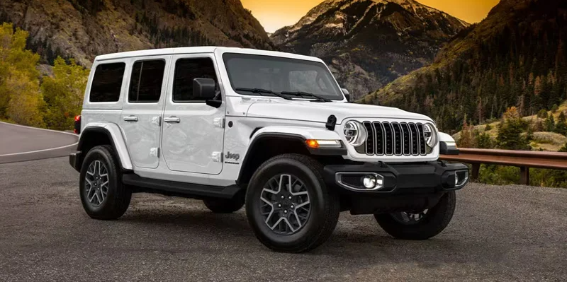 A white 2025 Jeep Wrangler parked on the side of the road.