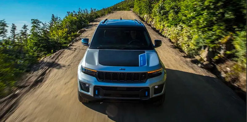 A 2025 Jeep Grand Cherokee driving down a dirt road.