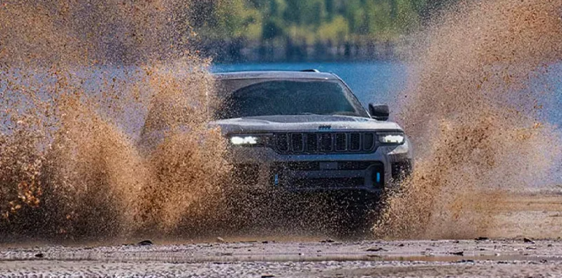 A silver 2025 Jeep Grand Cherokee off-roading.