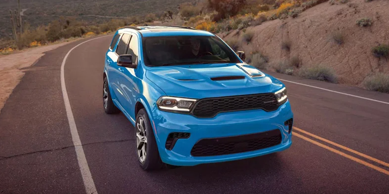 A blue 2026 Dodge Durango driving down the road.