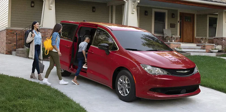 A red 2026 Chrysler Voyager parked in a driveway.